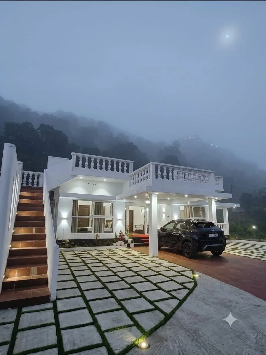 Villa entrance and staircase lit up in the evening mist